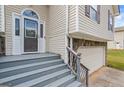 View of home's entryway with stone accents, gray stairs, and a white front door at 227 River Trace Ct, Mcdonough, GA 30253