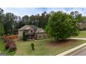 Aerial view showcasing a brick two-story home surrounded by lush greenery and manicured landscaping at 166 Nobility Ln, Mcdonough, GA 30252