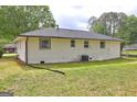 The back of the one-story home features brick and siding and the backyard has grass at 7279 Mayfair Cir, Jonesboro, GA 30236