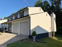 Rear view of two-story home with an attached two car garage, well maintained yard and patio at 2691 Old South Dr, Jonesboro, GA 30236
