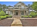 Inviting front porch with stone pathway leading to a beautiful home with manicured landscaping at 400 Conservatory Pt, Fayetteville, GA 30215