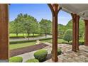 View of the lush front yard from the covered porch, showcasing mature trees and manicured landscaping at 400 Conservatory Pt, Fayetteville, GA 30215