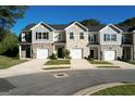 View of the townhouses featuring a brick facade, attached garage, and well-manicured front lawn at 142 Hampton Cir, Mcdonough, GA 30253