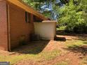 Back exterior view of a brick home with a small addition and exterior AC unit at 6186 Green Acres Sw Dr, Covington, GA 30014