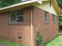 Close up of the side of a brick home with visible window frames at 6186 Green Acres Sw Dr, Covington, GA 30014
