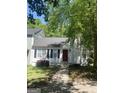 Charming home with a red front door, white siding and manicured front yard with mature landscaping at 1047 Plantation Nw Way, Kennesaw, GA 30144