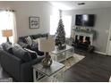 Inviting living room with fireplace, gray sofa, Christmas tree, and ample natural light at 1047 Plantation Nw Way, Kennesaw, GA 30144