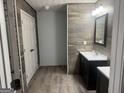 Modern bathroom boasts double sink vanity, decorative wood backsplash, and tiled flooring at 30 Wellington Trl, Covington, GA 30016