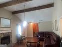 Cozy living room with hardwood floors, exposed beams, and a classic stone fireplace at 625 Locust Rd, Locust Grove, GA 30248