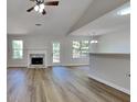 Open-concept living room with a fireplace, wood flooring, and natural light at 11616 Spring Lake Way, Fayetteville, GA 30215