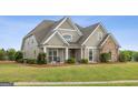 Beautiful home featuring stone accents, a manicured lawn, and a welcoming front porch at 2076 Towne Mill Ave, Canton, GA 30114