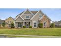 Beautiful home featuring stone accents, a manicured lawn, and a welcoming front porch at 2076 Towne Mill Ave, Canton, GA 30114
