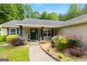 Charming front entrance with a well-manicured walkway and lush landscaping featuring colorful plants and decorative touches at 3775 Highway 16 E, Sharpsburg, GA 30277