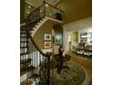 Welcoming foyer featuring a curved staircase with iron railings and hardwood floors and circular rug at 315 Westbourne Dr, Tyrone, GA 30290
