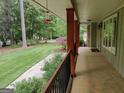 Long covered front porch featuring stone and wood supports with a view to the front yard at 205 Aberdeen Dr, Peachtree City, GA 30269