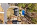 Overhead shot showing a swimming pool, driveway, and landscaping that surrounds the brick home at 212 Birkhill, Peachtree City, GA 30269