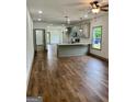 Spacious room with sleek hardwood floors and views of kitchen with pendant lighting at 304 N Dogwood Ave, Social Circle, GA 30025
