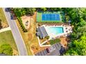 Aerial view of community amenities including the pool, tennis court, playground, parking, and clubhouse at 120 Lyndhurst Way, Sharpsburg, GA 30277