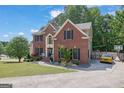 Brick home with lush lawn, landscaping, a basketball hoop, and a driveway at 4410 Red Rock Pt, Suwanee, GA 30024