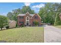 Charming brick home with a manicured front lawn and long driveway at 4410 Red Rock Pt, Suwanee, GA 30024