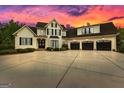 Spacious two-story home with a three-car garage and a wide concrete driveway at sunset at 215 Sheridan Ln, Peachtree City, GA 30269