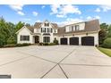 Front view of a spacious two-story home with a three-car garage and a wide concrete driveway at 215 Sheridan Ln, Peachtree City, GA 30269
