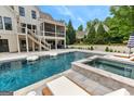 Backyard swimming pool and jacuzzi with an outdoor living area and a screened-in porch at 215 Sheridan Ln, Peachtree City, GA 30269