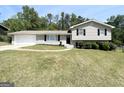 Charming split-level home with gray brick, mature trees and an expansive green lawn at 5906 Pine Hurst Way, Douglasville, GA 30135