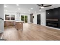 Bright, open-concept living room with modern lighting, hardwood floors, and open layout into kitchen at 410 Queen Aliese Ln, Jonesboro, GA 30236