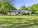 Beautiful one-story brick home with a spacious front lawn and mature trees at 115 Linda Way, Fayetteville, GA 30215