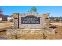 Stone entrance sign to The Gates at Pates Creek community with landscaping at 1816 Quaker St, Hampton, GA 30228