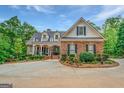 Beautiful brick home with detailed landscaping, an arched entryway, and black shutters at 95 Weslyan Way, Oxford, GA 30054