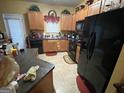 Functional kitchen featuring light wood cabinets and black appliances at 1255 Chinon Pt, Lithonia, GA 30058