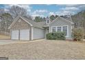 View of the house's side with garage and the front entrance featuring stone detail and manicured landscaping at 131 Meadowbrook Ln, Grantville, GA 30220