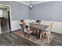 Dining room with modern light fixture, four chairs, a dining table, and wainscoting details at 176 Fairoaks Cir, Stockbridge, GA 30281
