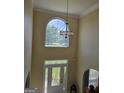 Bright foyer with high ceilings, large arched window, stylish chandelier, and decorative glass front door at 176 Fairoaks Cir, Stockbridge, GA 30281