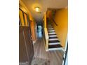Inviting staircase featuring hardwood steps and white risers against yellow walls at 6444 Charter Way, Lithonia, GA 30058