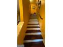 Inviting staircase featuring hardwood steps and white risers against yellow walls at 6444 Charter Way, Lithonia, GA 30058
