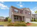 Beautifully landscaped yard of a brick two-story home featuring a covered porch at 5396 Pennington Ct, South Fulton, GA 30349