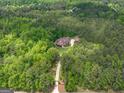 A beautiful brick home, with an accompanying guest house, sits secluded on a heavily wooded lot with an extended driveway at 210 Short Rd, Sharpsburg, GA 30277
