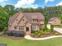 Stunning brick home with manicured landscaping, mature trees, long driveway, and a guest house on a beautiful day at 210 Short Rd, Sharpsburg, GA 30277