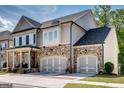 Beautiful home exterior showcasing stone accents, attached two car garage, and meticulously maintained landscaping at 10140 Grandview Sq, Duluth, GA 30097