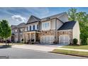 Inviting home exterior with stone accents, a welcoming porch, and an attached two-car garage at 10140 Grandview Sq, Duluth, GA 30097