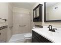 Well-lit bathroom featuring a shower, toilet, decorative backsplash and vanity with a dark wood finish at 40 N Villa Rd, Villa Rica, GA 30180
