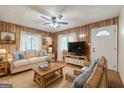 Inviting living room featuring comfortable seating, warm wood paneling, and bright windows with sheer curtains at 40 N Villa Rd, Villa Rica, GA 30180
