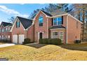 Two-story brick home featuring an attached two-car garage and well-maintained landscaping at 6322 Shell Sw Dr, Atlanta, GA 30331
