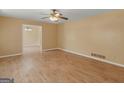 Spacious living room with hardwood floors, ceiling fan, neutral walls, and views to dining area at 3 Ridge Dr, Hampton, GA 30228