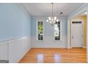 Sunny dining area with hardwood floors, wainscoting, and views from two bright windows at 507 Rippling Dr, Temple, GA 30179