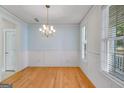 Bright dining room with hardwood floors, wainscoting, modern chandelier and natural light at 507 Rippling Dr, Temple, GA 30179