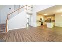 Open-concept floor plan with staircase, laminate floors, and view into kitchen at 205 Huntwood Ct, Ellenwood, GA 30294